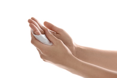 Woman cleaning hands with paper tissue on white background, closeup