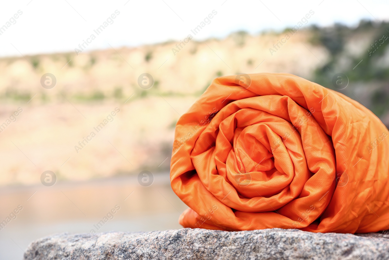 Photo of Rolled sleeping bag on sunny day outdoors. Space for text