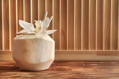 Photo of Fresh coconut drink in nut on wooden table