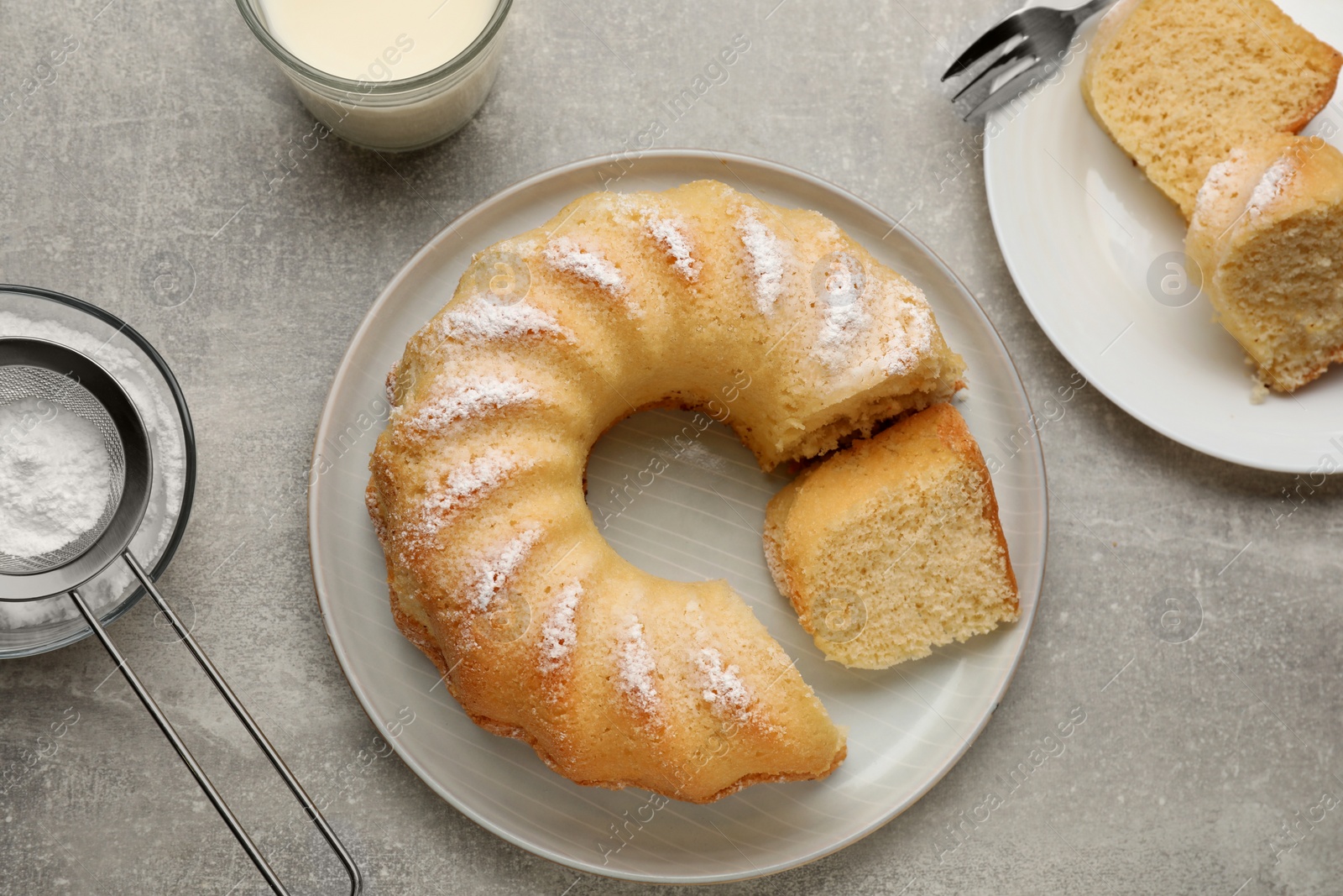 Photo of Delicious sponge cake served on gray table, flat lay