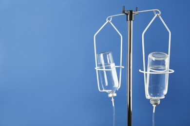 Photo of IV infusion set on blue background. Space for text
