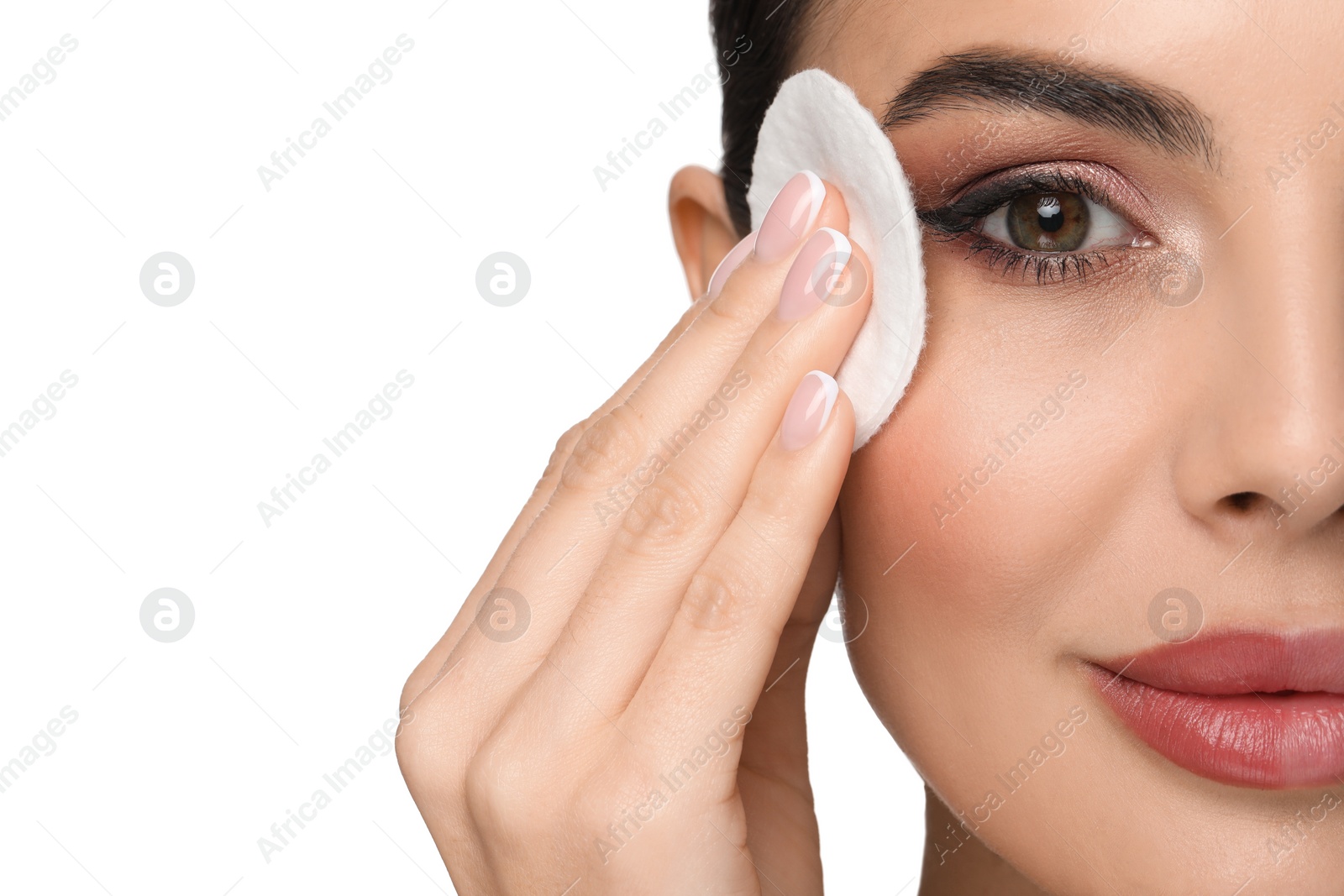 Photo of Beautiful woman removing makeup with cotton pad on white background, closeup