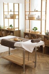 Photo of Stylish room interior with massage table in spa salon