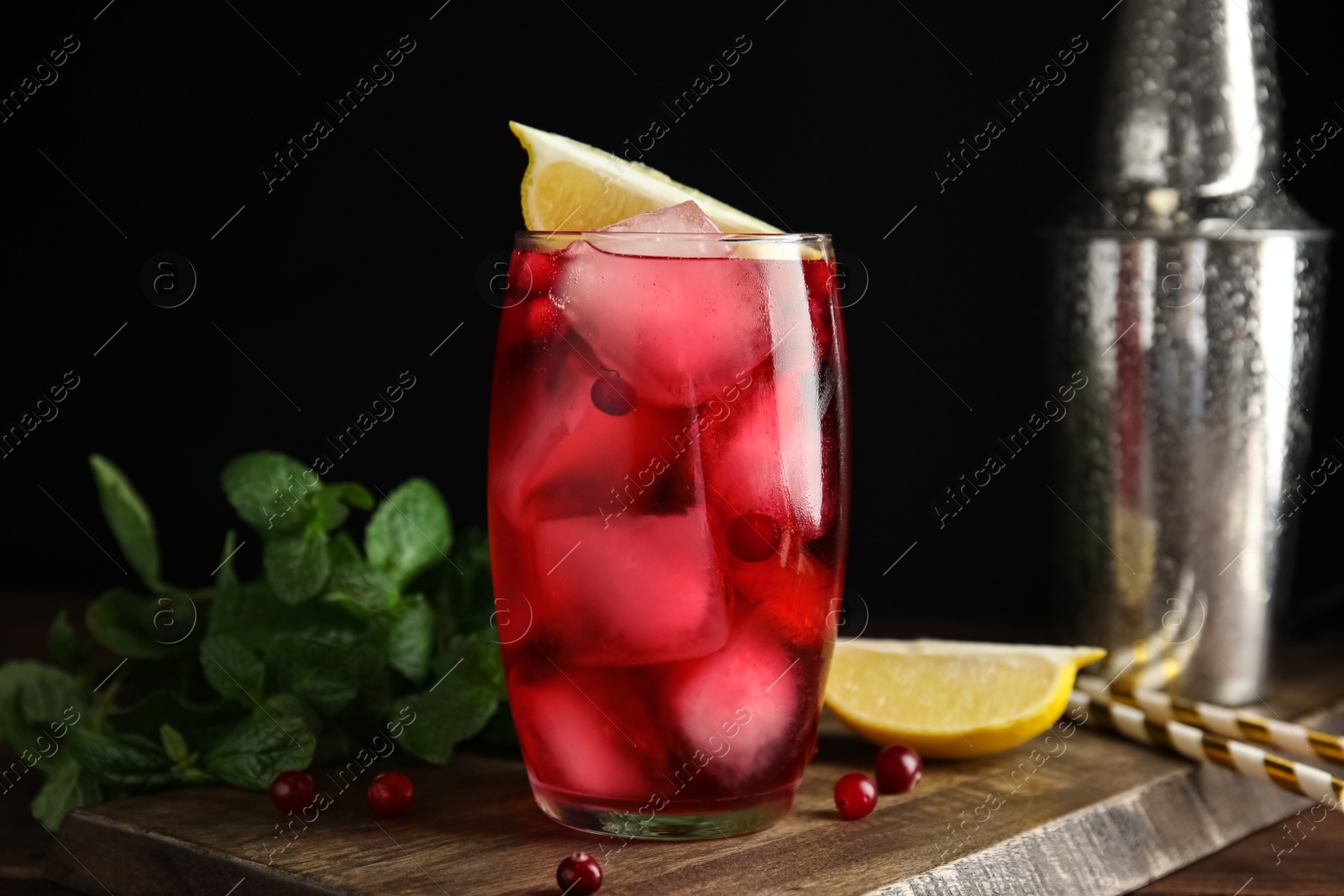 Photo of Tasty refreshing cranberry cocktail and fresh ingredients on wooden table