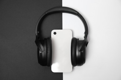 Photo of Modern wireless headphones and smartphone on color background, top view