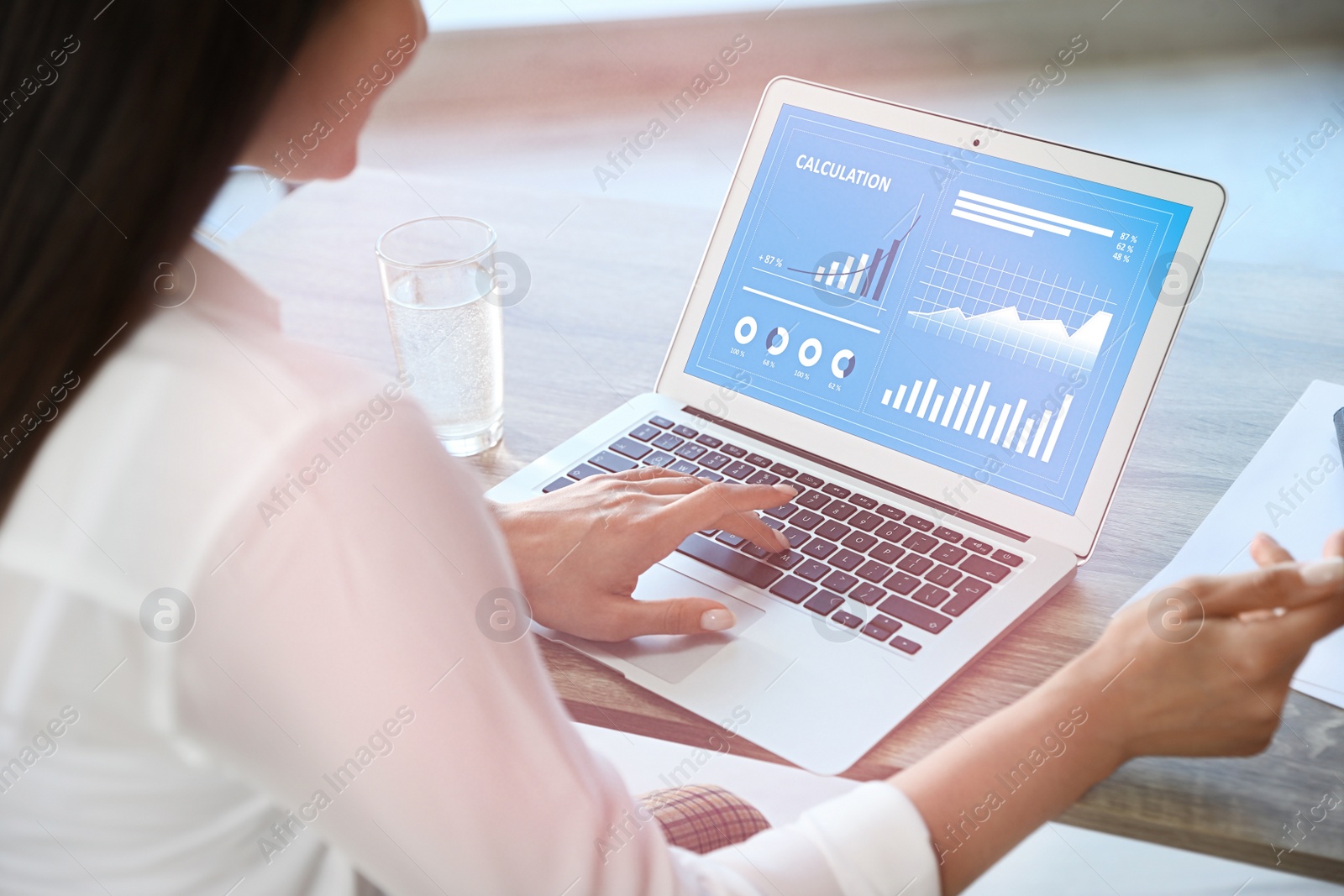 Image of Woman using laptop at table in office, closeup. Business analytics