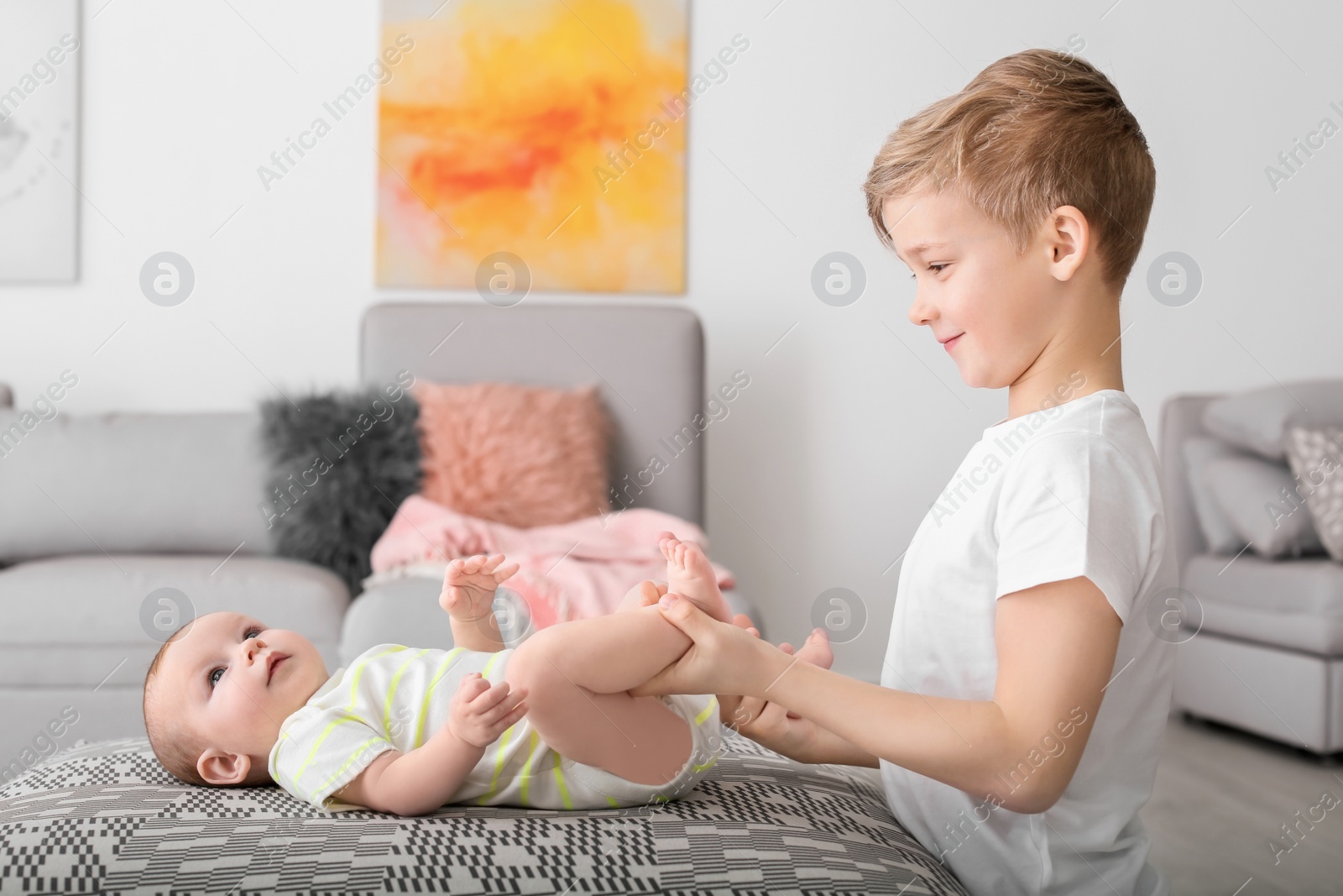 Photo of Cute boy playing with little baby at home