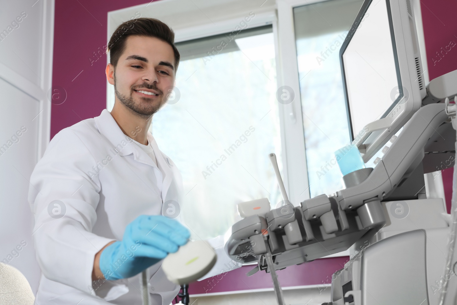 Photo of Sonographer using modern ultrasound machine in clinic