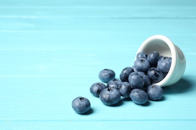 Photo of Juicy and fresh blueberries on wooden table. Space for text