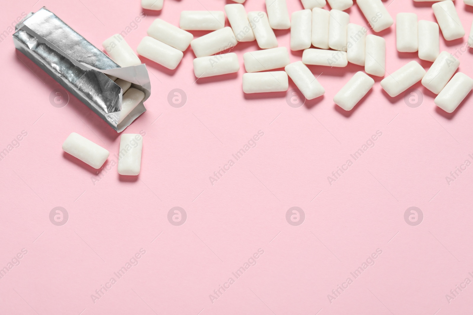 Photo of Pack with tasty chewing gums on pink background, closeup. Space for text