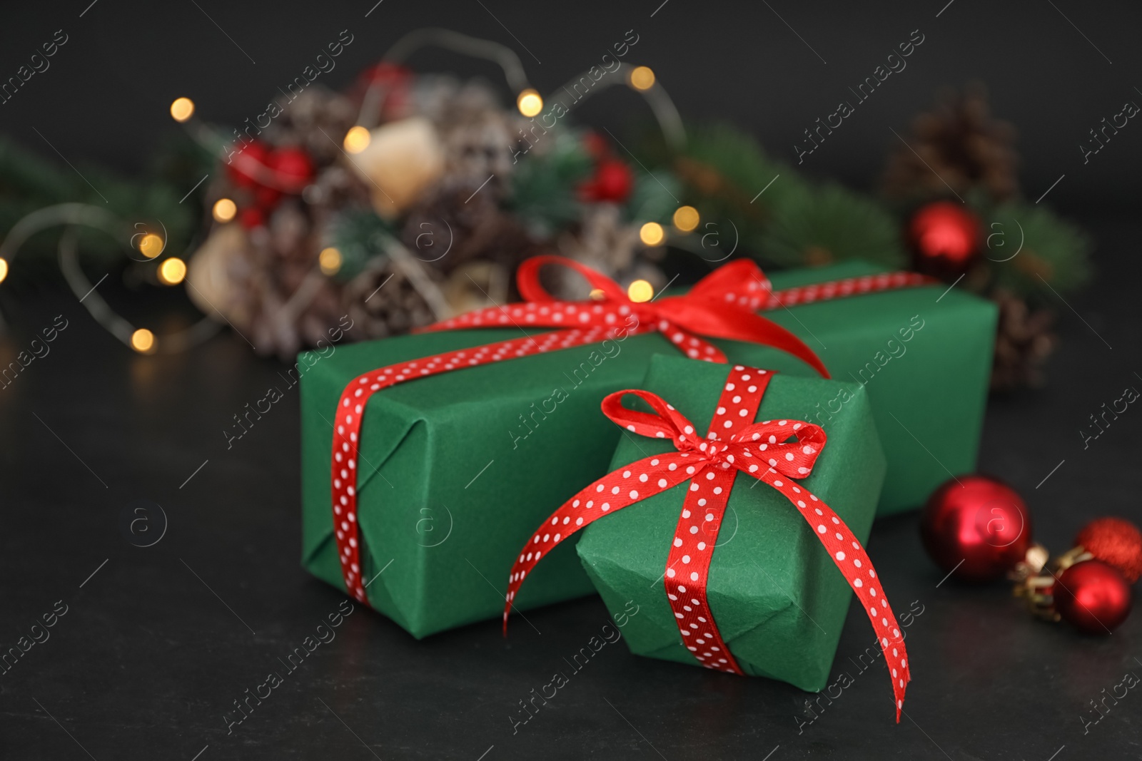 Photo of Green Christmas gift boxes with red bows on black table