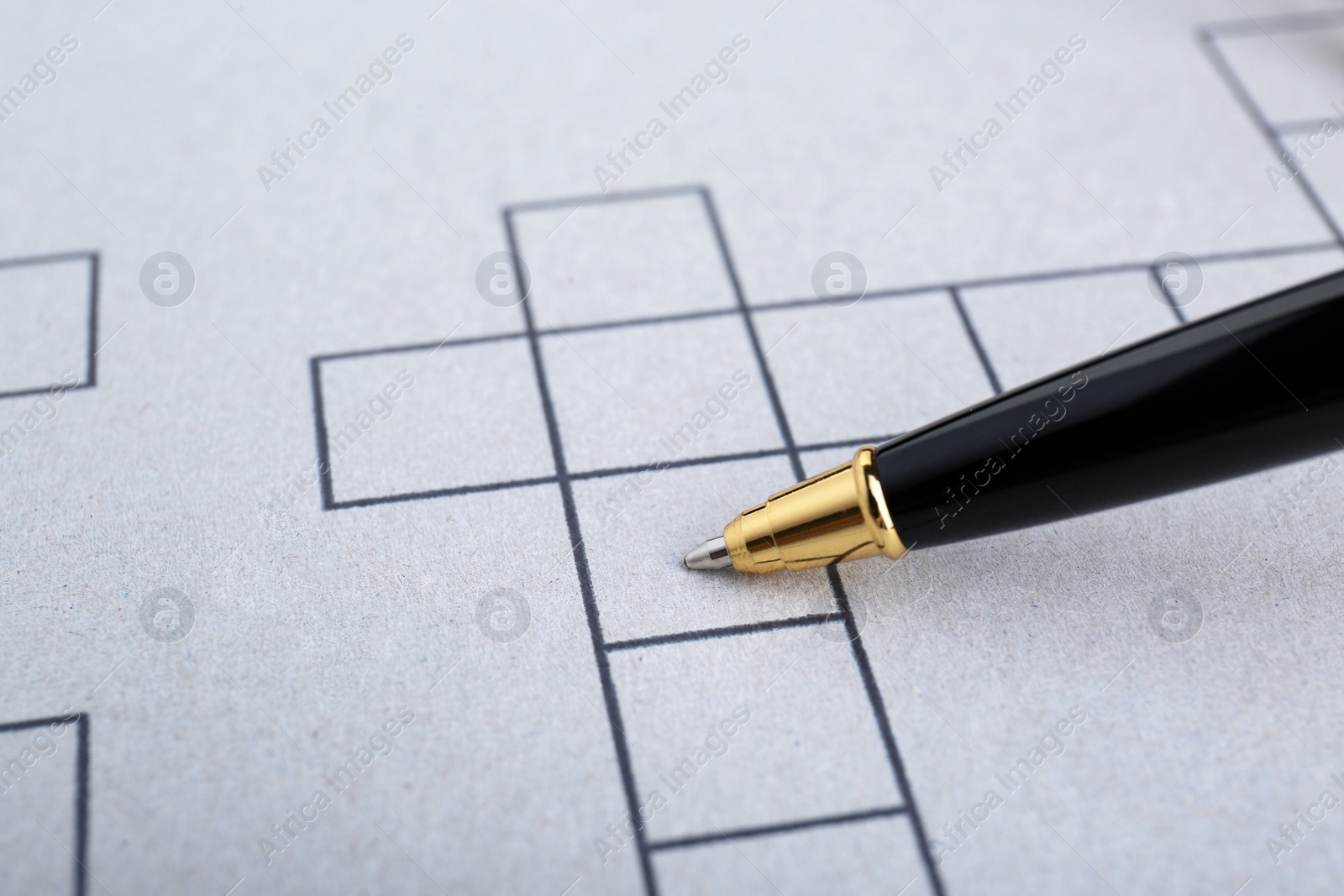 Photo of Pen on blank crossword, closeup. Space for text