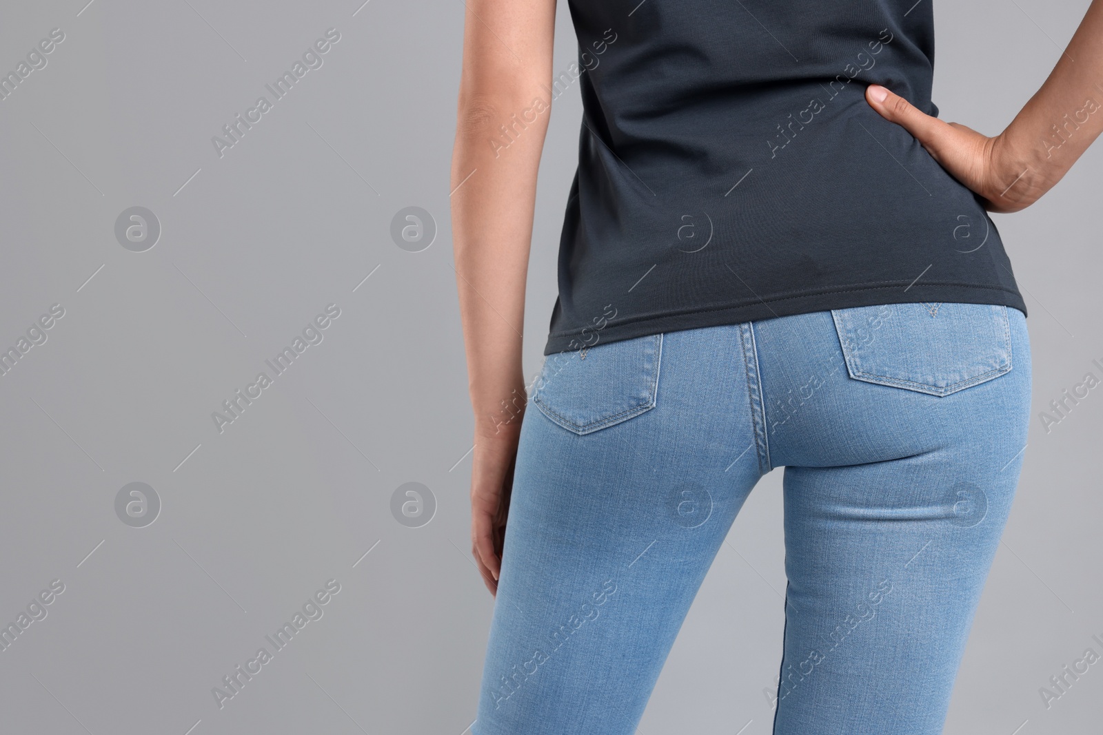 Photo of Woman wearing stylish jeans on light gray background, closeup. Space for text