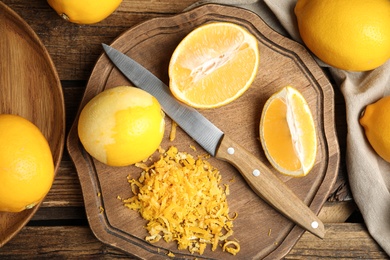 Lemon zest and fresh fruits on wooden table, flat lay