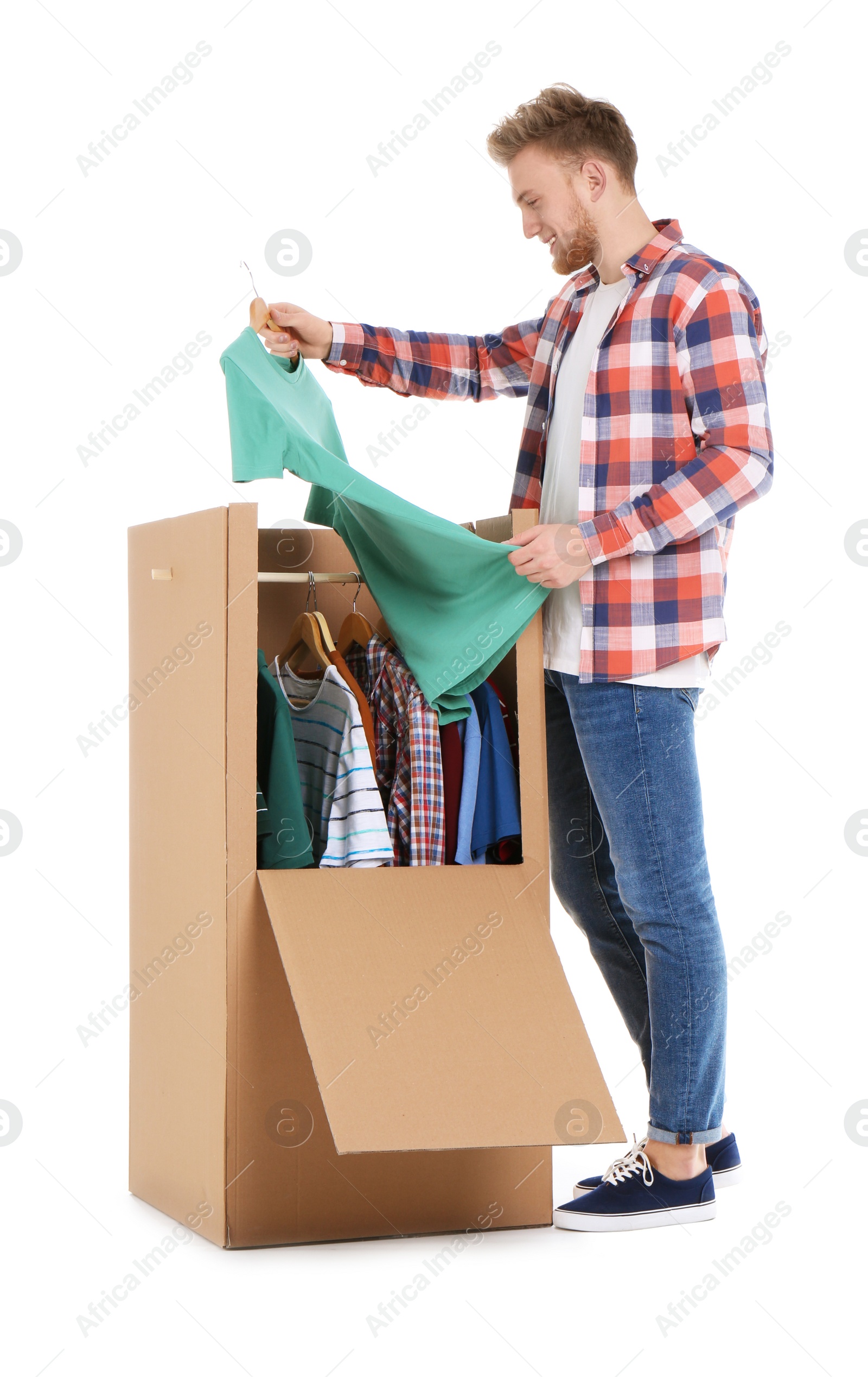 Photo of Young man near wardrobe box on white background