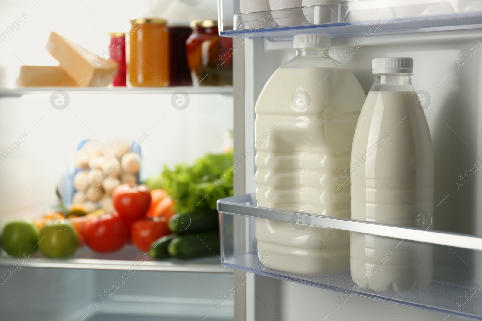 Photo of Gallon and bottle of milk in refrigerator, closeup. Space for text