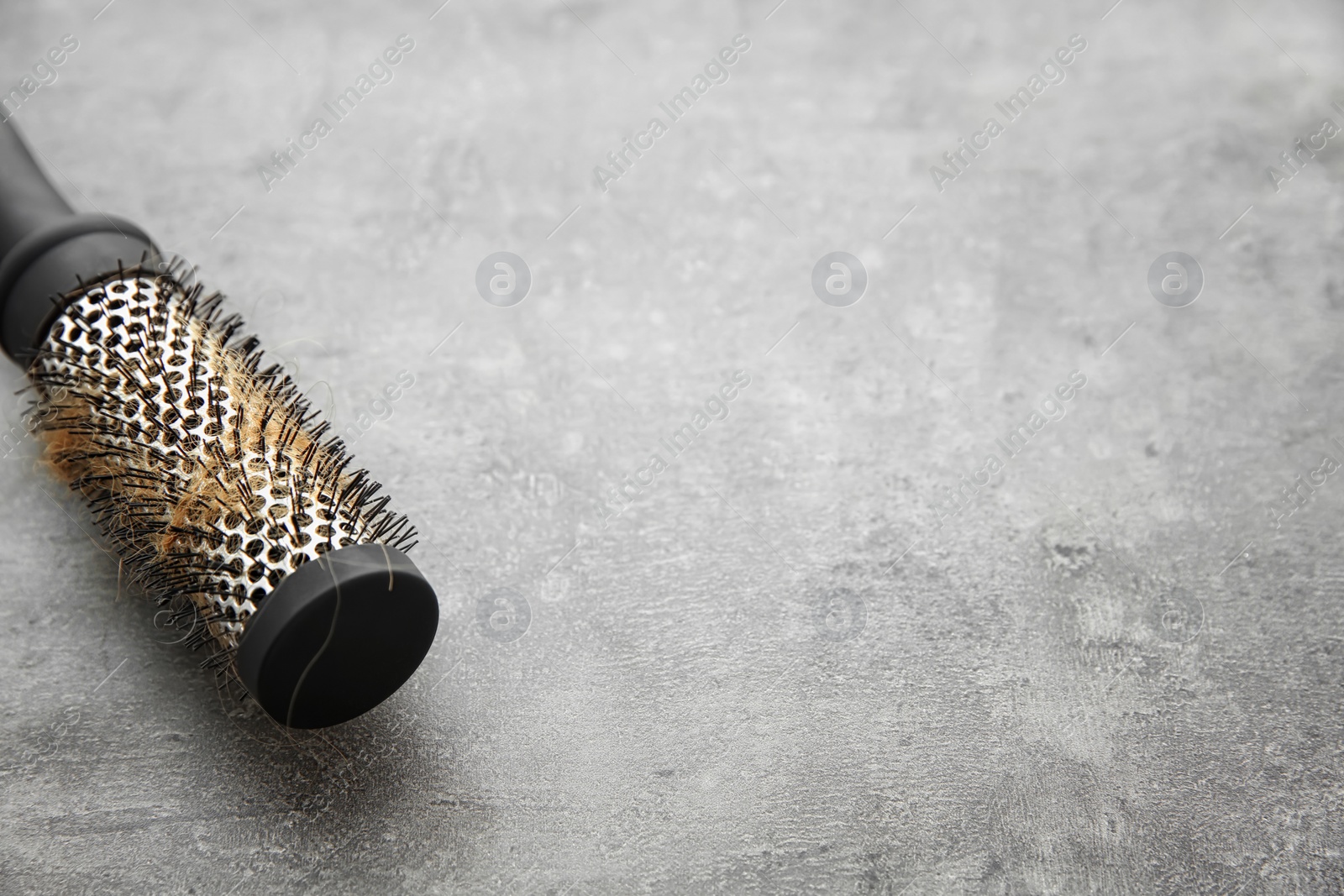 Photo of Brush with lost hair on gray table. Alopecia problem