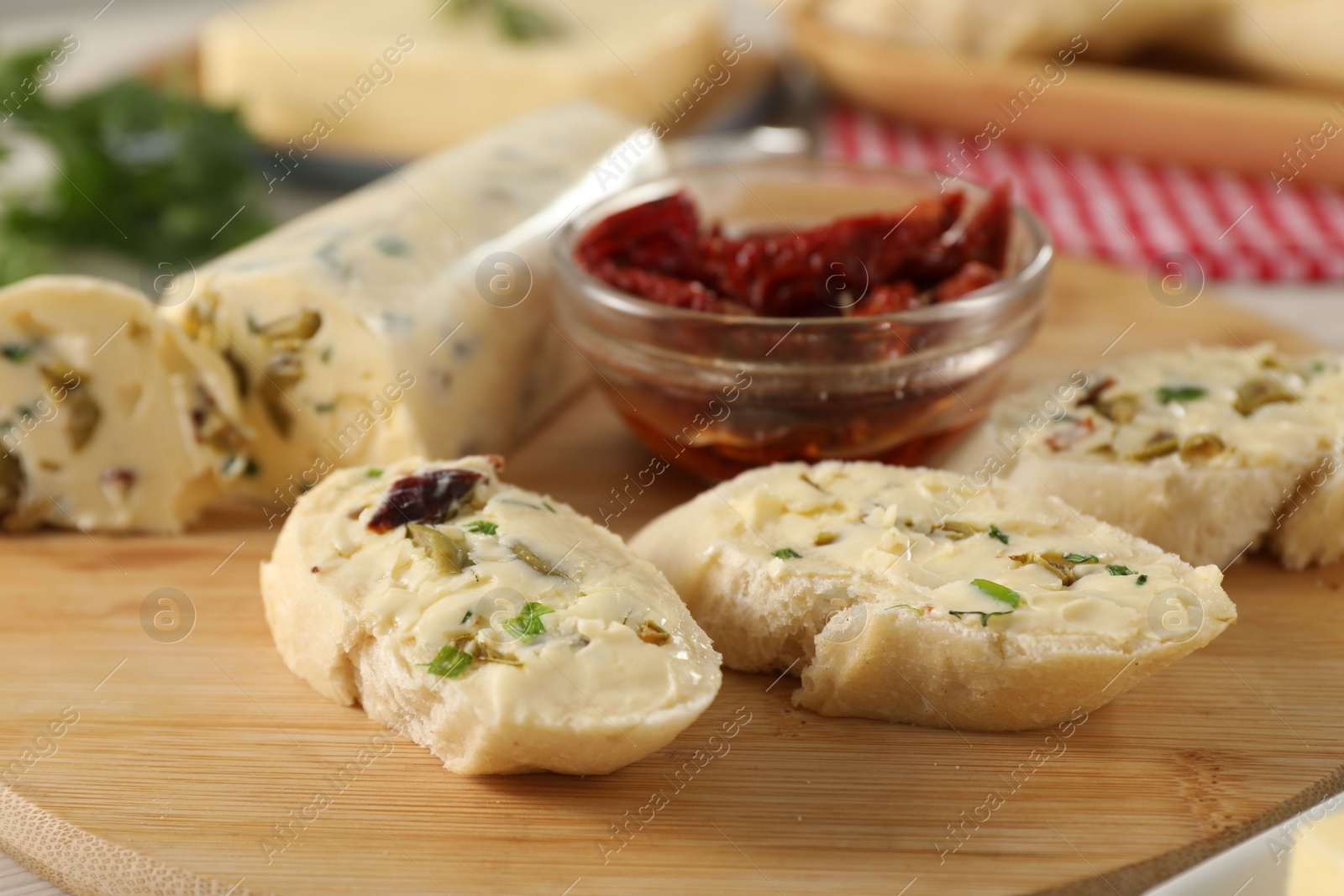 Photo of Tasty butter with olives, green onion, chili peppers and bread on table, closeup