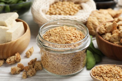 Photo of Dehydrated soy meat and other organic products on white wooden table, closeup