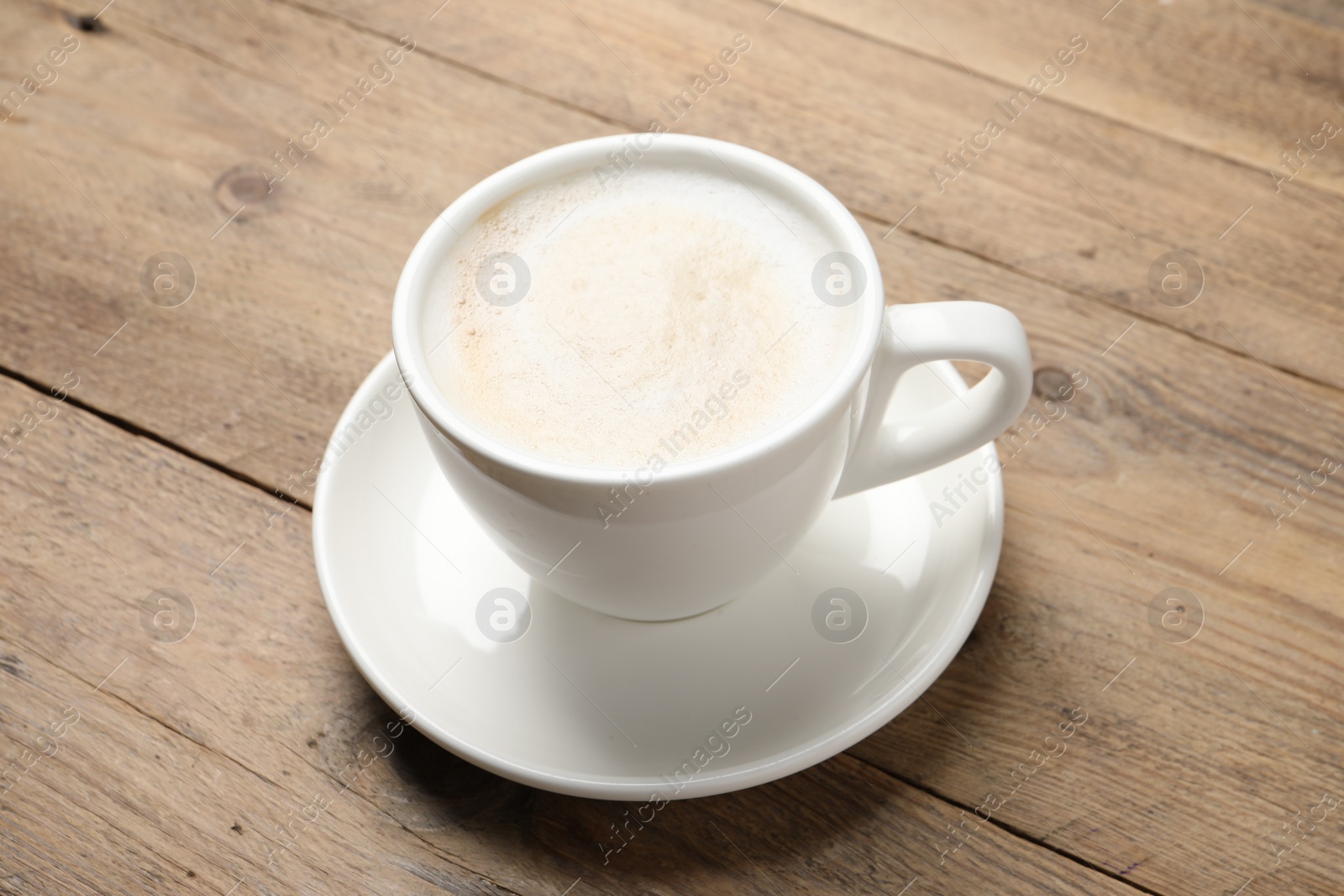 Photo of Cup of aromatic coffee on wooden table