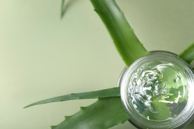 Aloe leaves and cosmetic gel on olive background, flat lay. Space for text