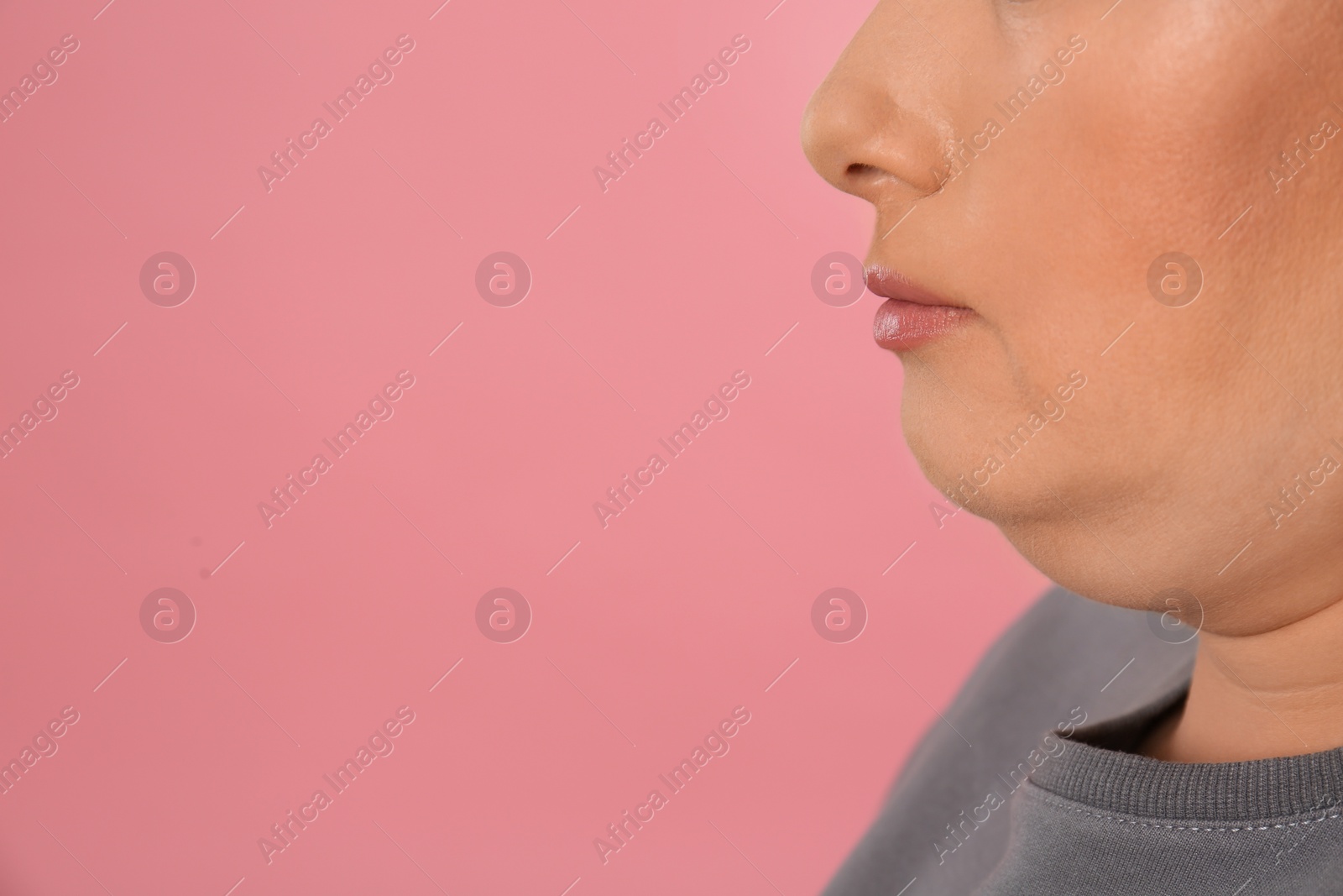 Photo of Woman with double chin on pink background, closeup. Space for text