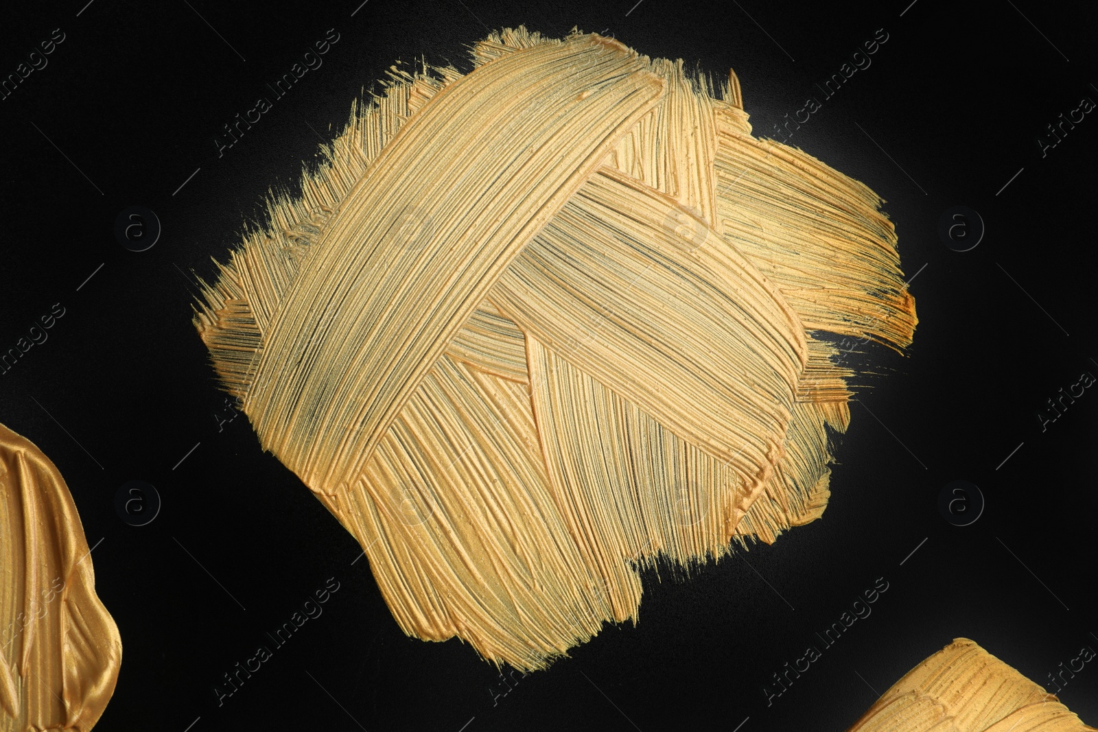 Photo of Golden paint brush strokes on black background