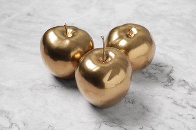 Photo of Beautiful golden apples on white marble table, closeup