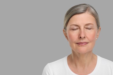 Portrait of senior woman with aging skin on grey background, space for text. Rejuvenation treatment