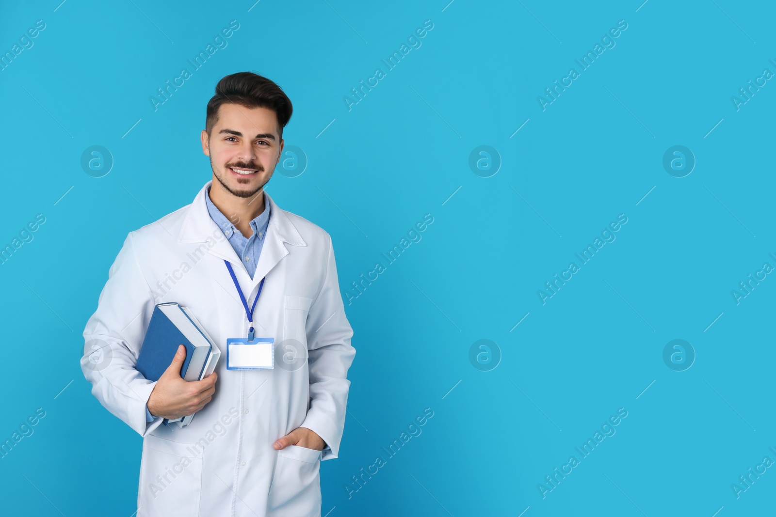 Photo of Young medical student with books on color background. Space for text