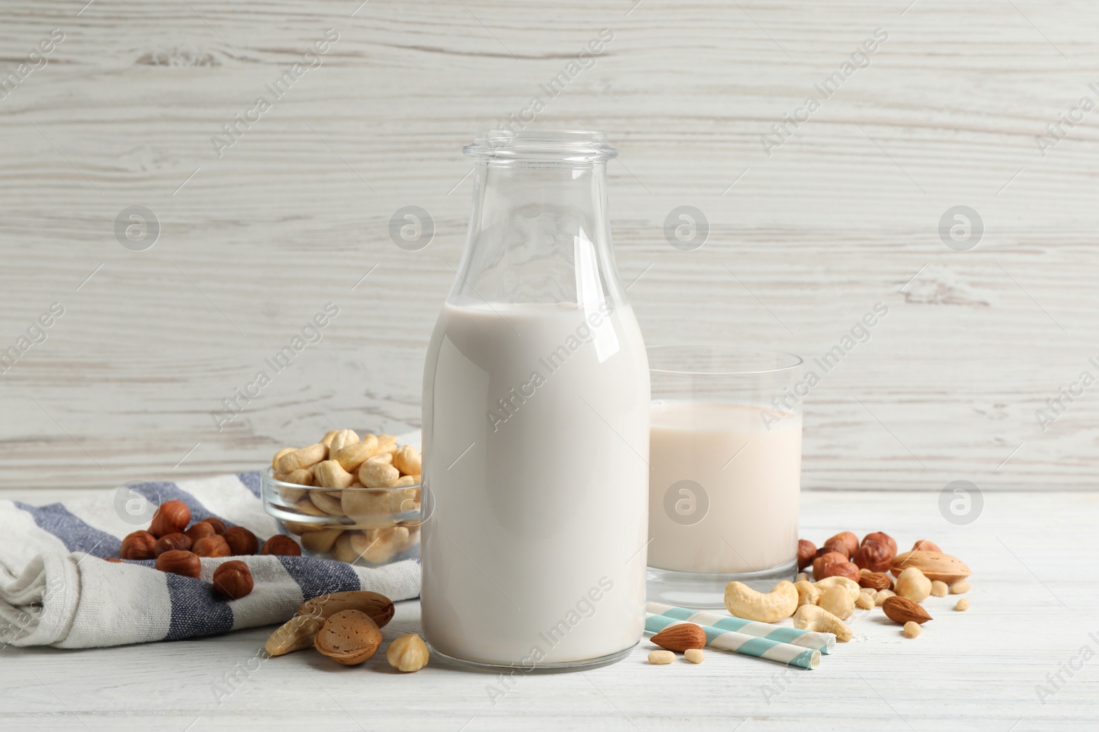 Photo of Different nut milks on white wooden table