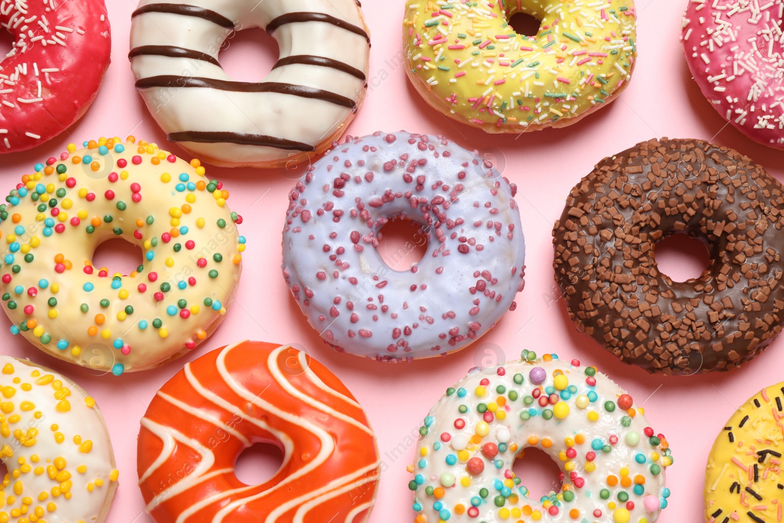 Photo of Delicious glazed donuts on pink background, flat lay