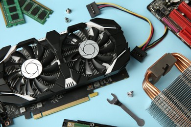 Photo of Graphics card and other computer hardware on light blue background, above view