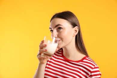 Photo of Milk mustache left after dairy product. Woman drinking milk on orange background