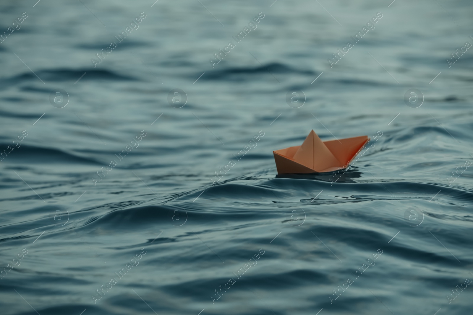 Photo of Paper boat floating on water outdoors. Space for text