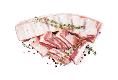 Photo of Fresh raw pork ribs with peppercorns and thyme isolated on white, top view