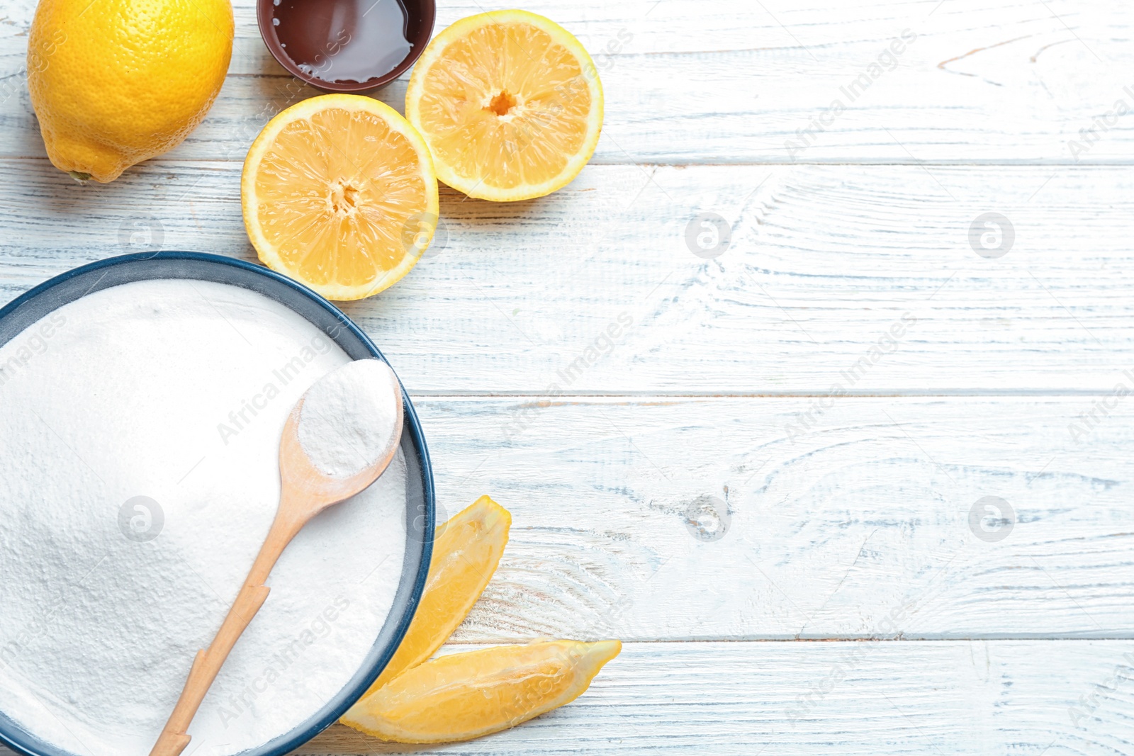 Photo of Flat lay composition with baking soda and lemons on white wooden background. Space for text