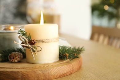 Photo of Burning scented conifer candles and Christmas decor on wooden table, closeup. Space for text