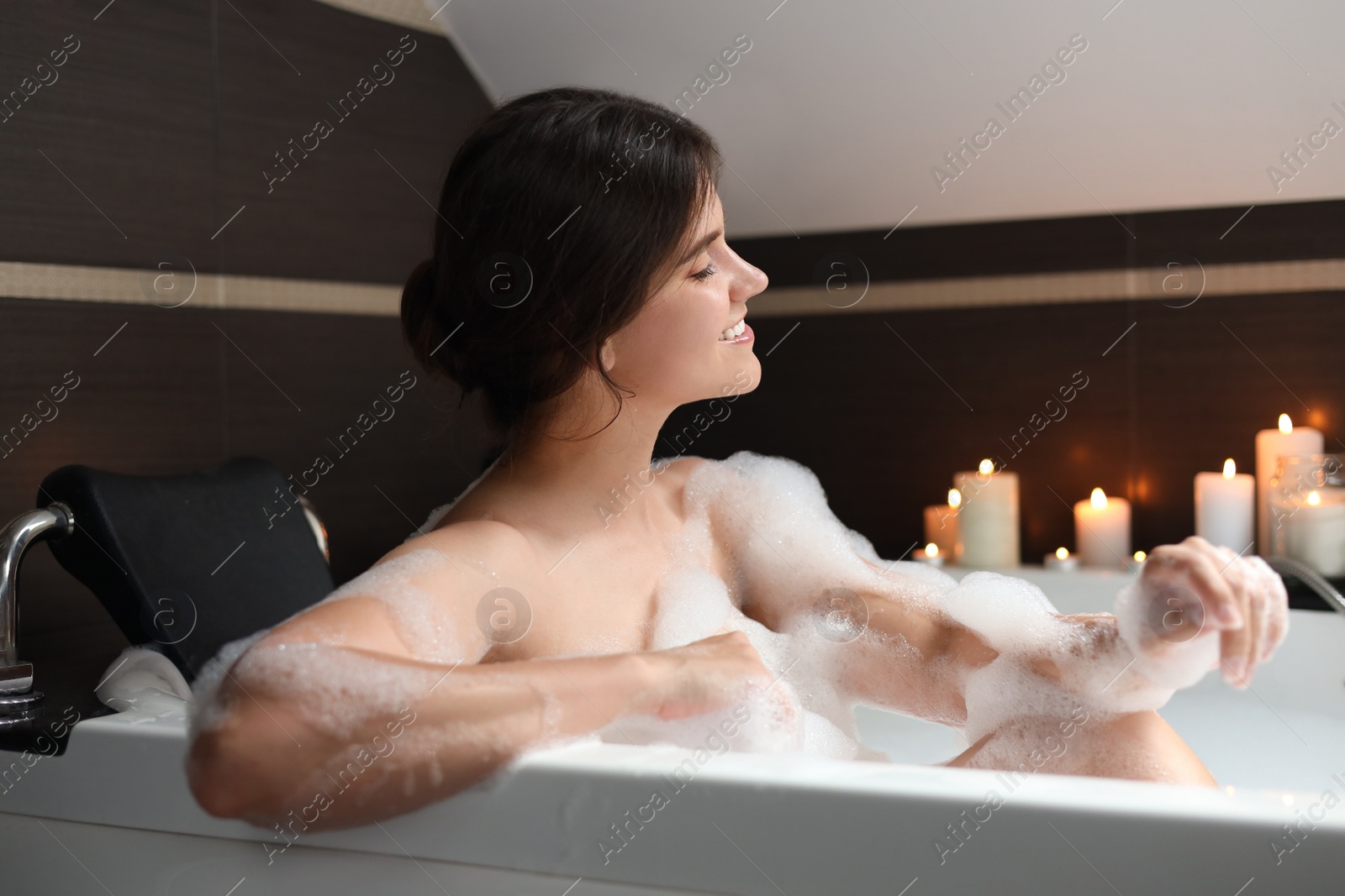 Photo of Happy beautiful woman taking bubble bath. Romantic atmosphere