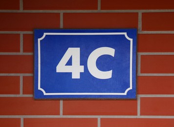 Plate with house number 4 on brick wall
