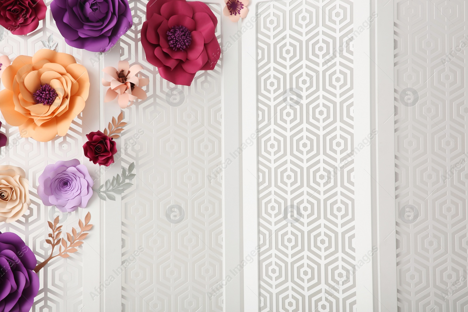 Photo of Ornate white folding screen with floral decor on light background. Beautiful photo zone