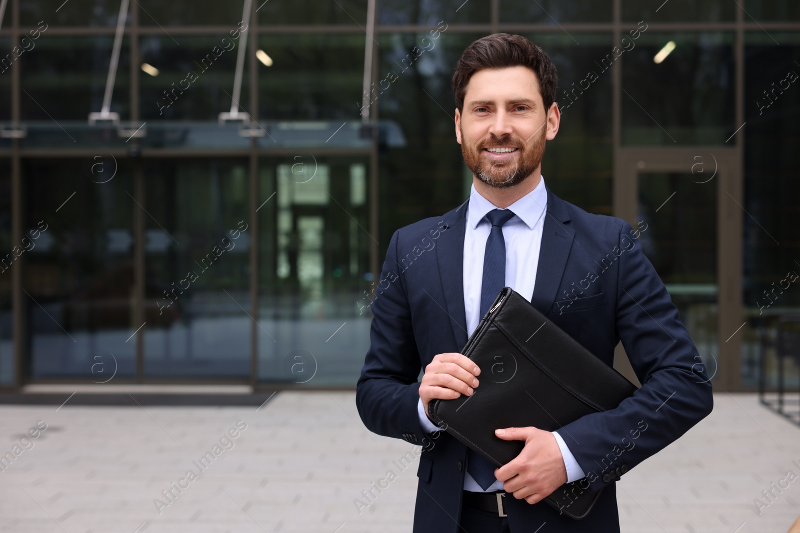 Photo of Real estate agent with leather portfolio outdoors. Space for text