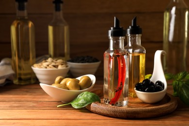 Photo of Different cooking oils and ingredients on wooden table