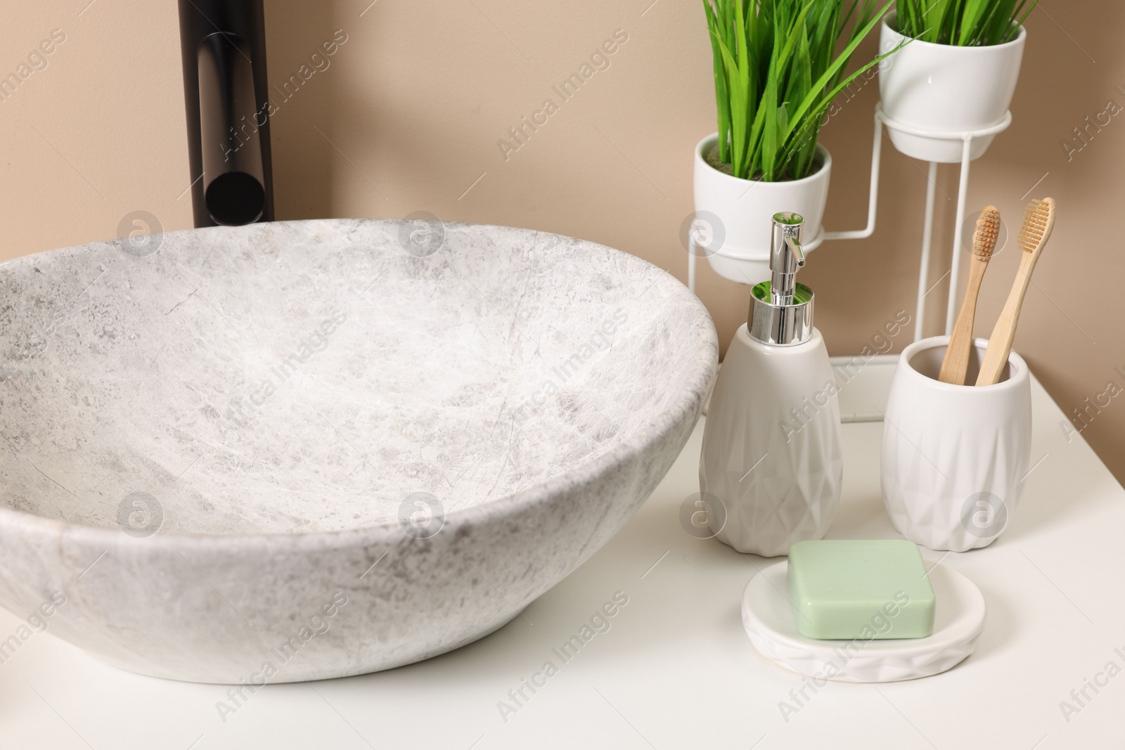 Photo of Different bath accessories and personal care products near sink on bathroom vanity