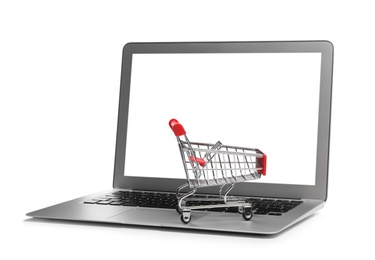 Internet shopping. Laptop with small cart isolated on white