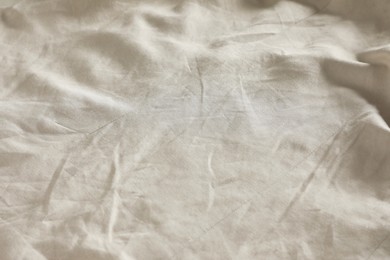 Photo of Crumpled dark beige fabric as background, closeup view