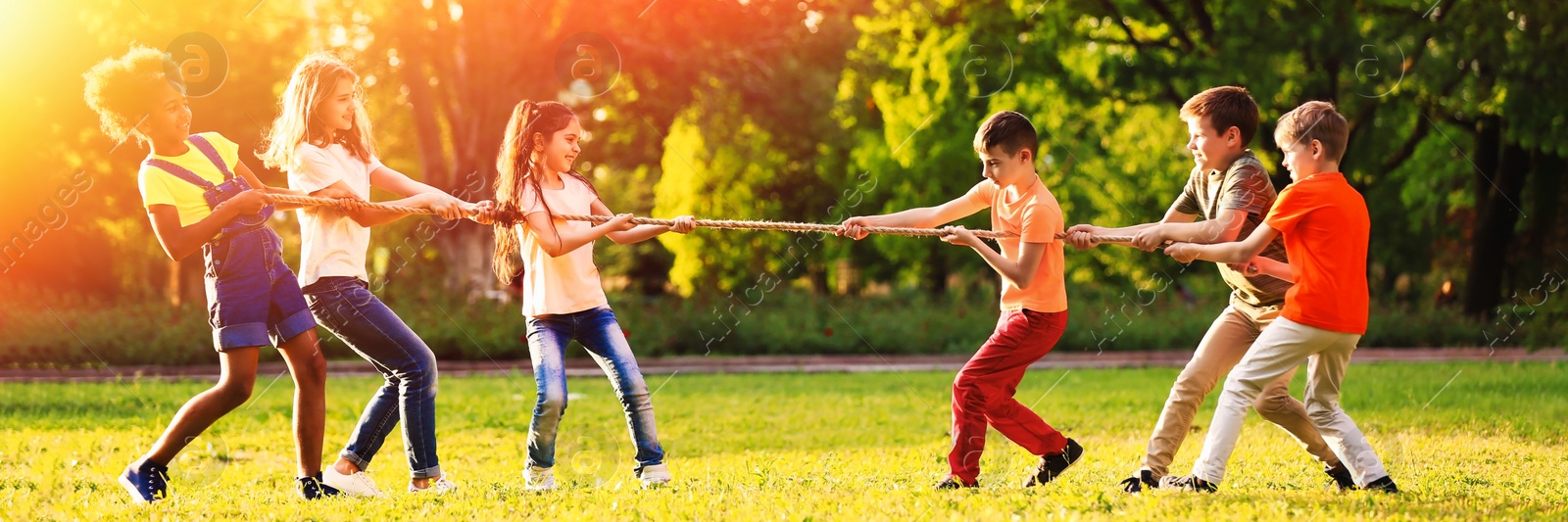 Image of Cute little children playing with rope outdoors on sunny day. Banner design