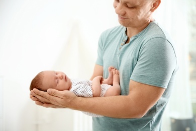 Photo of Man holding his newborn baby at home