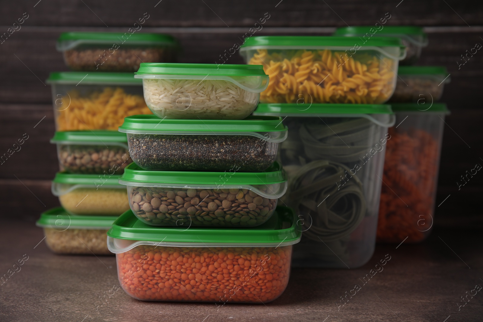 Photo of Plastic containers filled with food products on brown table