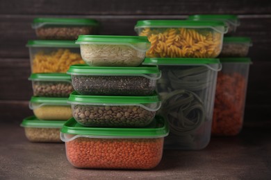 Photo of Plastic containers filled with food products on brown table